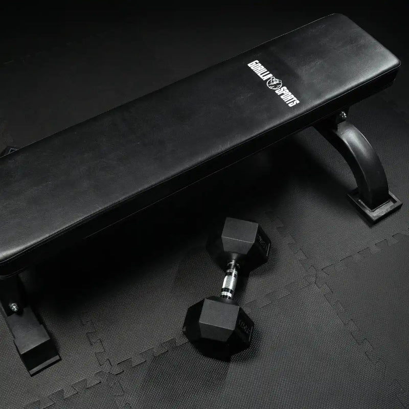 flat bench and hex dumbbell on protective floor mat